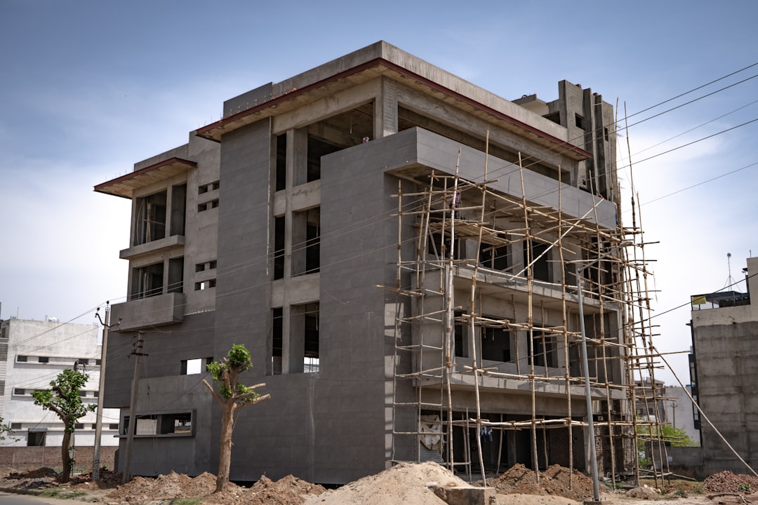 A multi-story concrete building under construction with bamboo scaffolding on the exterior
